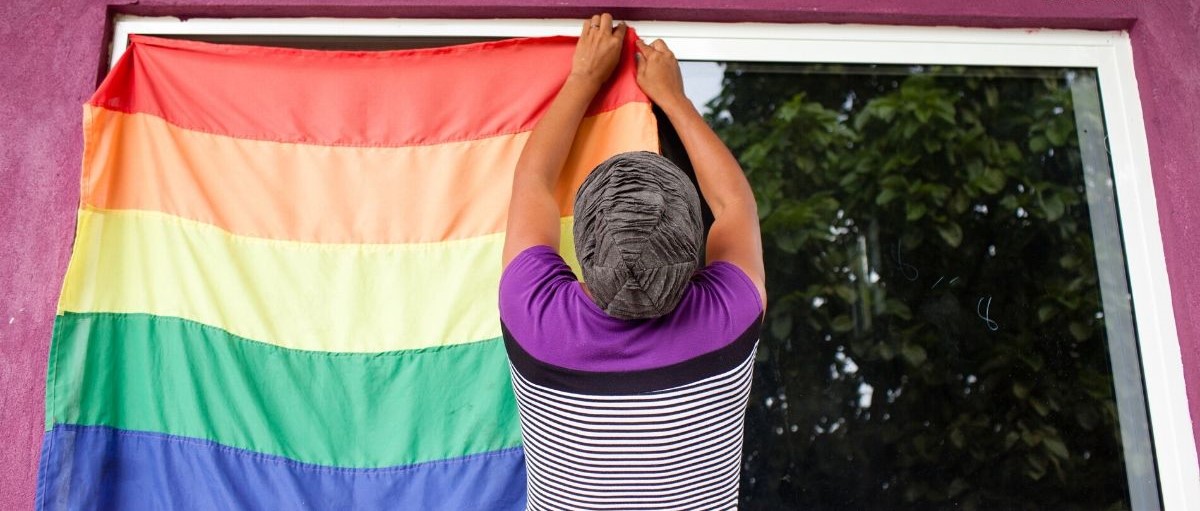 Hombre colgando bandera LGBT