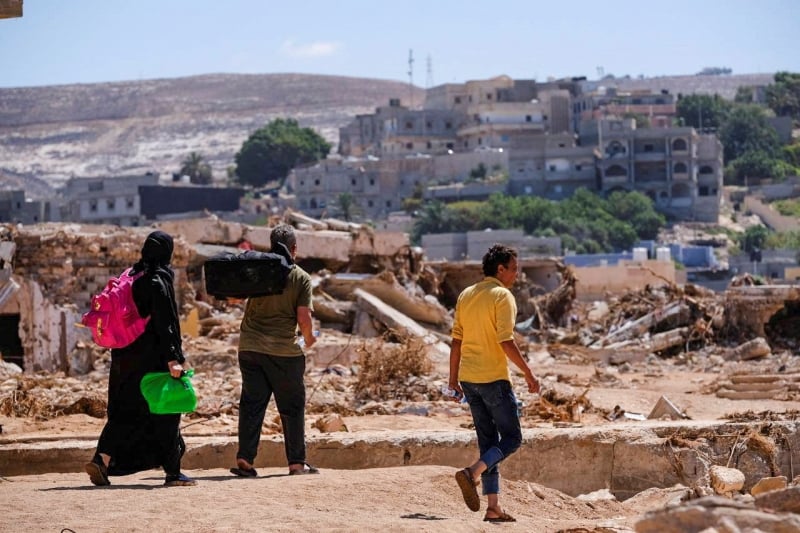 Libya. People walk amidst the rubble after powerful storm and flooding